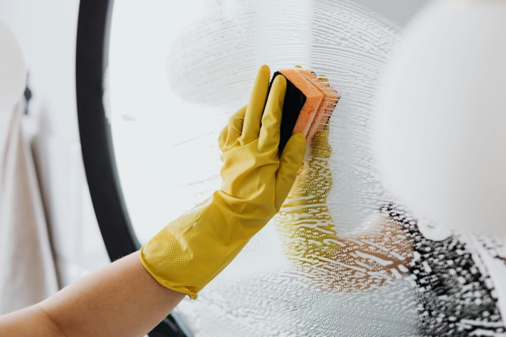 pexels-photo-4239146-4239146 Anonymous person in yellow rubber gloves using simple sponge for cleaning mirror in bathroom